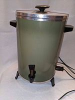 Front view of olive green electric coffee urn showing spigot, handles, power cord