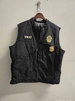 Front view of black SWAT vest with badge attached