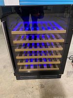 Closed wine cooler showing exterior, glass door, blue LED, shelves