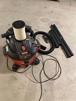 Full vacuum with hose, wands, nozzle and cord visible