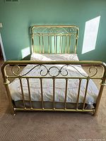 Full view of assembled brass bed frame with mattress to show scale
