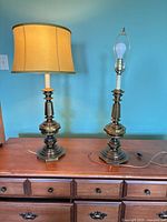 Front view of both brass lamps on dresser