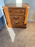Front view of one Kroehler nightstand showing three drawers and hardware