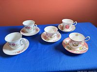 Overview of five teacup and saucer sets on table