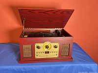 Turntable lid open showing platter, tonearm and control panel