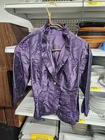 Front view of purple embroidered satin blouse on hanger, showing collar, buttons and sleeve length