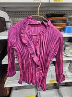 Front view of magenta crinkle blouse on hanger