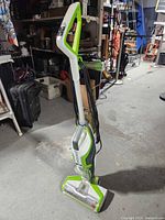 Full side view of upright Bissell floor cleaner showing handle, body, and brush head