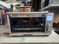 Front view of Breville Compact Smart Oven showing door, handle, stainless body, digital controls
