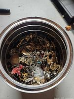 Top view into coffee can showing numerous mixed jewelry parts