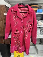 Front view of magenta embroidered pea coat on hanger