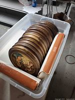 Tote containing stack of round ANRI plaques and two boxes