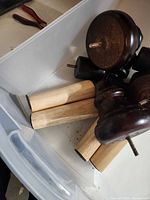 Overview of dark brown turned legs and light wood cylindrical legs in bin