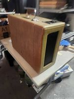 Suitcase-style Crosley CR89 turntable closed, showing brown faux-leather exterior and speaker grille