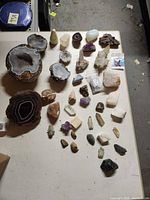 Top view of entire collection on table; shows large agate geode half, agate slice and numerous crystal specimens