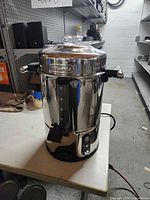 Full view of De'Longhi stainless steel 50-cup coffee urn on table