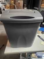 Front view of grey Fellowes paper shredder with bin attached