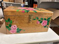 Front view showing floral painting, latch clasp