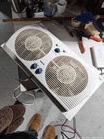 Top view of white Holmes twin window fan showing two blades, control knobs, power cord