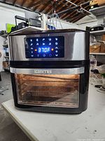 Front view showing digital display, controls, glass door and interior basket