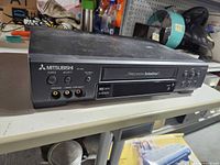 Front view of Mitsubishi HS-U448 VCR showing branding, Precision TurboDrive door and control buttons