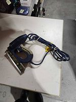 Full view of Nail Master 2 ET200 electric brad nail gun with cord coiled