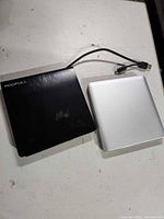 Top view showing both drives, Roofull logo visible, attached cable on black drive