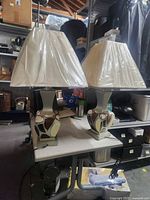 Pair of ceramic table lamps on table, full view with shades