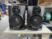 Front view of both Sharp speakers showing woofer, tweeter, and overall design