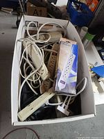 Top view of box showing assorted loose power strips and one boxed surge protector