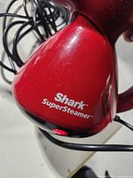 Close-up of Shark SuperSteamer logo and indicator light on red body