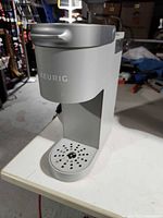 Front three-quarter view showing slim profile, drip tray, branding