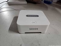 Top view of Sonos Bridge showing logo and pairing button