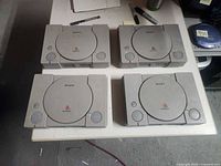 Top view of four Sony PlayStation consoles closed