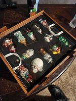 Top tray showing 16 of the blown glass ornaments secured in foam inside wooden box
