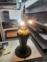 Full view of lamp lit showing height, missing shade, twin sockets