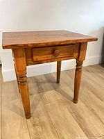 Front view showing table, drawer and turned legs