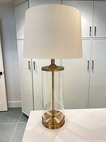 Full view of lamp showing shade, glass body and brass base