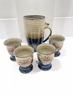 Front view of pitcher and four goblets showing glaze colors and forms