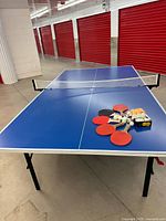 Table fully assembled with net, paddles and balls on surface