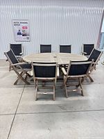 Full view of teak extension table with eight folding chairs arranged