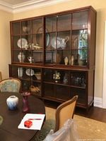 Cabinet loaded with dinnerware showing upper and lower sliding mullioned glass doors