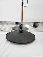 Pendant light resting on surface, showing flat wheel shade