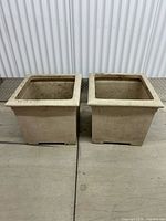 Two identical square fiberglass planters side by side
