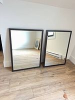 Front view of both matching mirrors leaning against wall