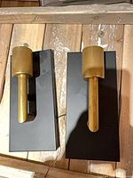 Front view showing both brass sconces upright on black backplates