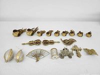 All 19 gold ornaments laid out on white surface