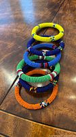 Stack of six beaded bracelets on wood surface