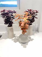 Front view of three vases with faux eucalyptus