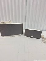 PLAY:5 and PLAY:3 speakers side by side with power cords visible